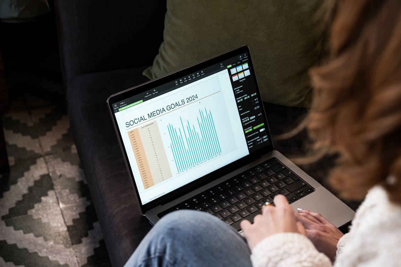 Mastering the First Impression: Your intriguing post title goes here A woman reviewing 2024 social media goals on a laptop at home.