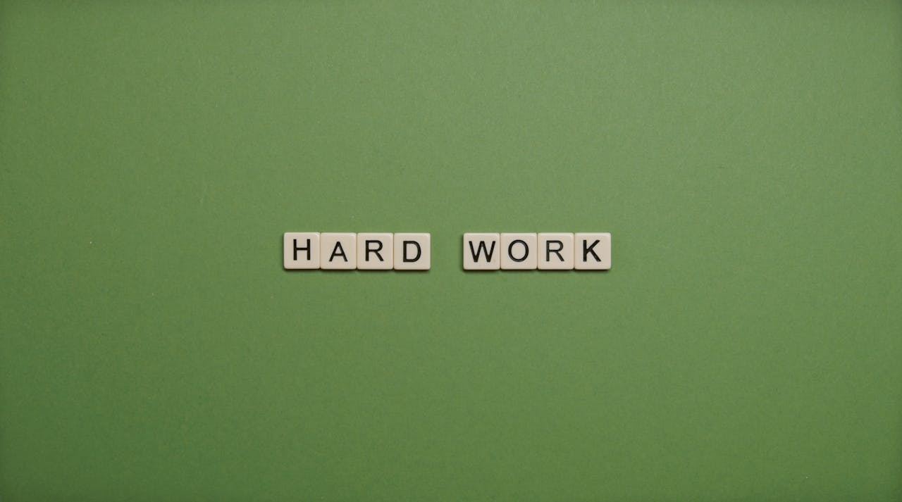 The Art of Drawing Readers In: Your attractive post title goes here Tiles spelling 'hard work' on a green background symbolizing diligence and effort.